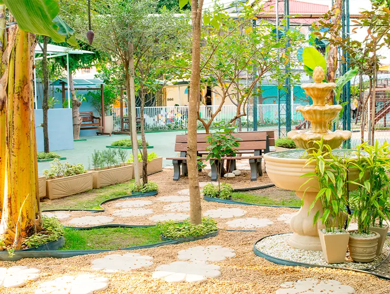 Jardim com fonte e caminhos de pedra na EcoEscola Monteiro Lobato
